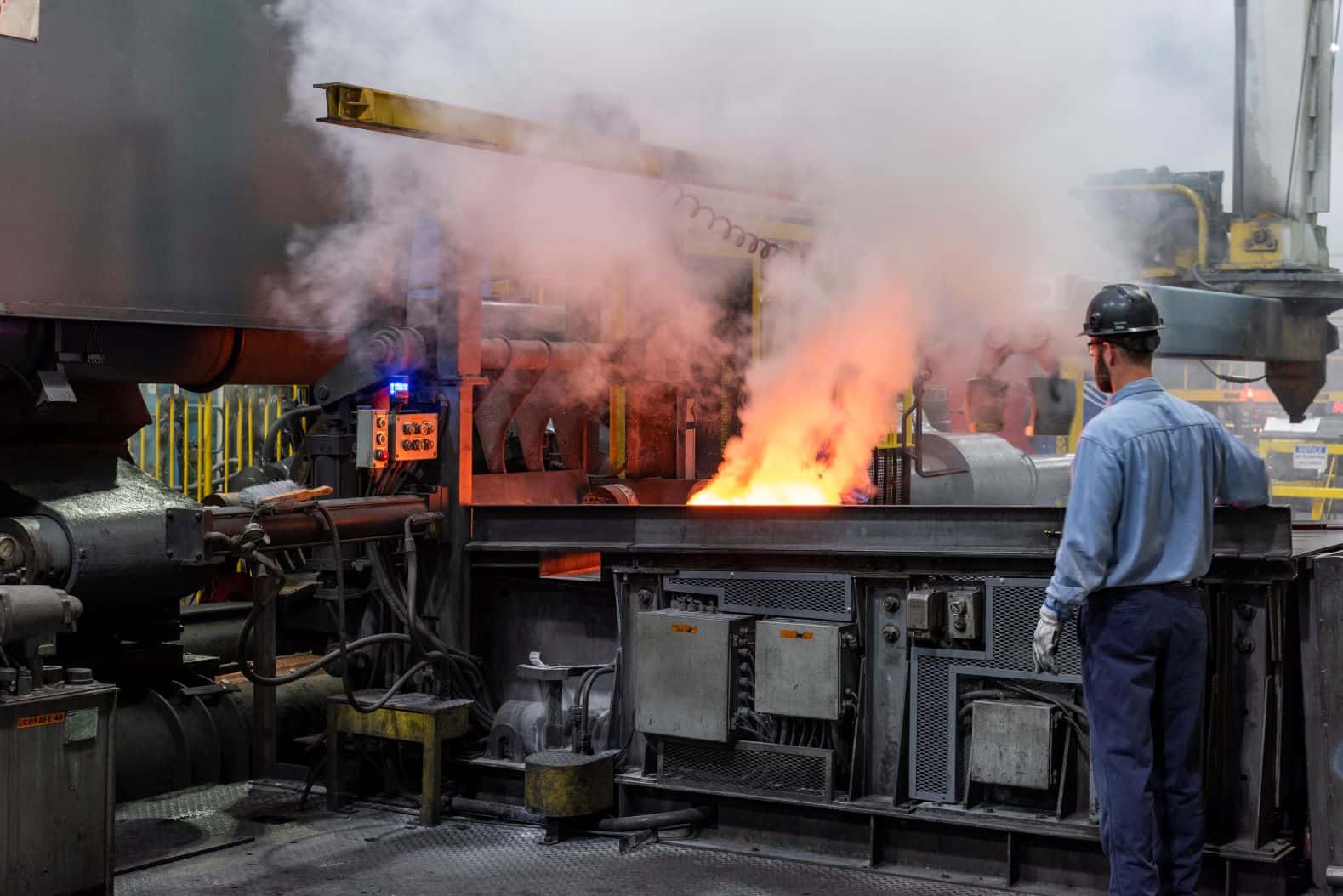 Man watching machinery with large flame