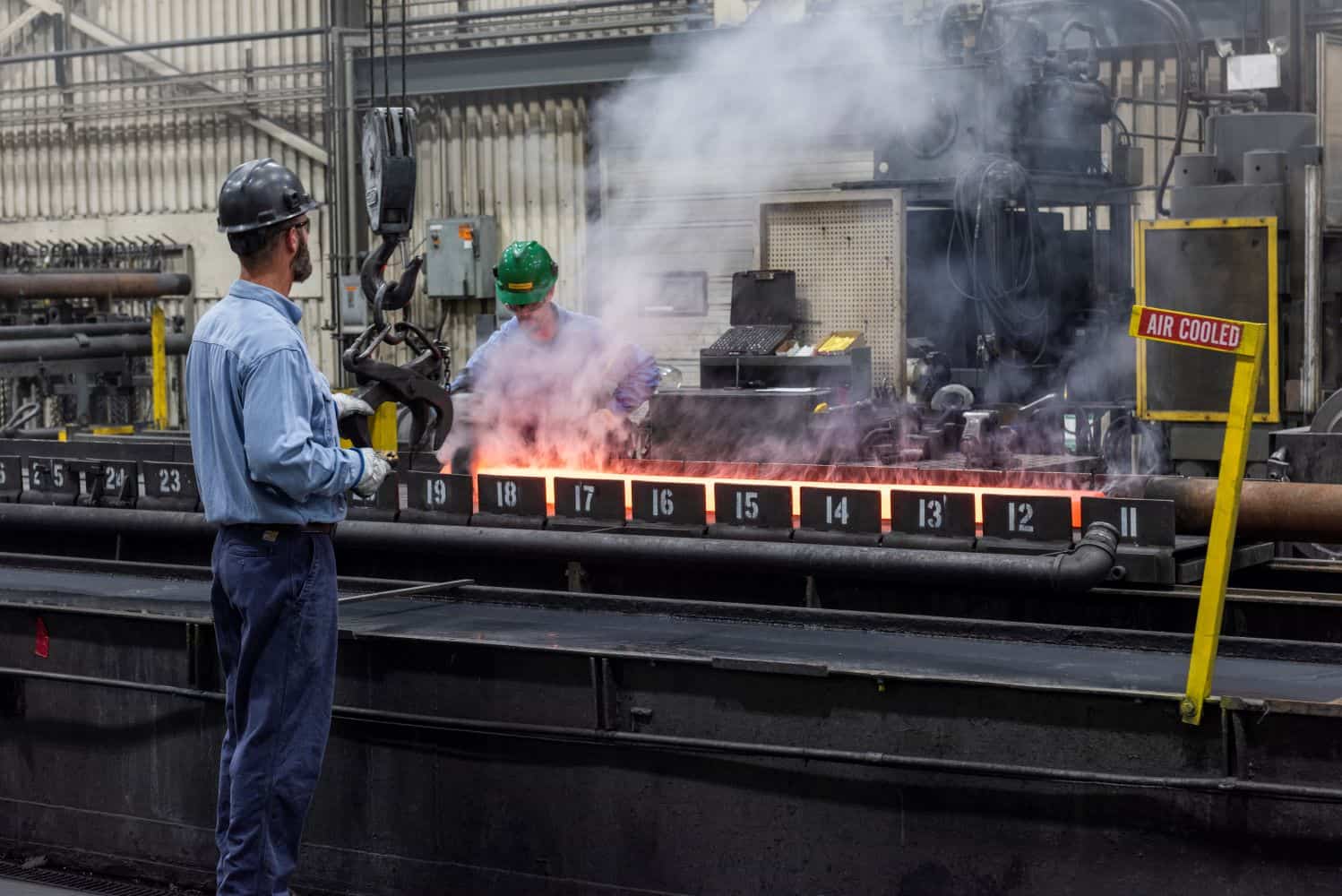 Two men working on extrusion line